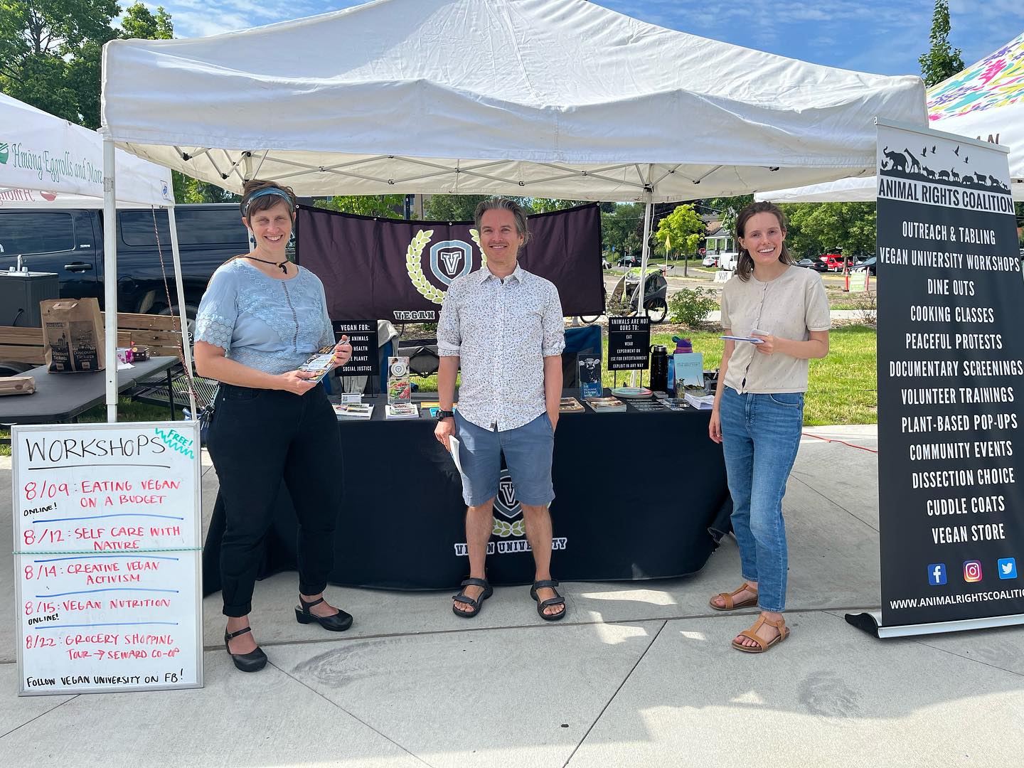 Three people standing in front of presentation booth